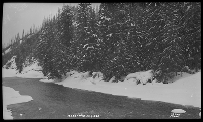 River in the snow near Wallace, Idaho. The bank of the river is covered and snow, and trees are behind it.