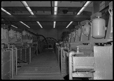 The Lucky Friday Mine milling and processing equipment. Several machines are located on both sides of a walkway, and faucets with running water can be seen.