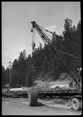 A disassembled mine hoist on a train at the Lucky Friday Mine near Mullan, ID. A crane is loading or unloading parts from the train.
