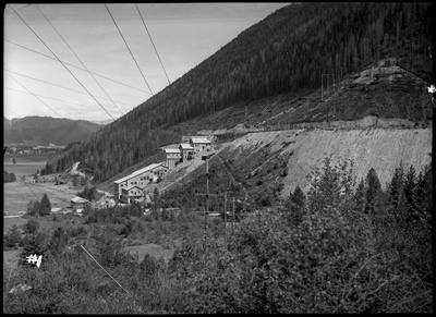 Image of the Silver Summit mine complex from a distance. There are trees between the photographer and the mine.