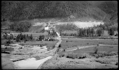 Image overlooking Silver Summit mine and the surrounding landscape. The mine is far off in the distance, a few roads are visible, and there are trees throughout.