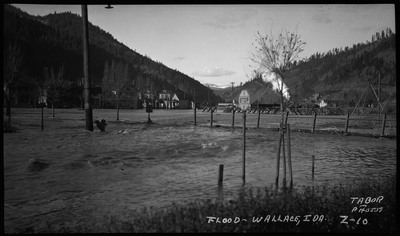 Street view of the Placer Creek flood in Wallace, Idaho. A stop sign can be seen with buildings in the distance.