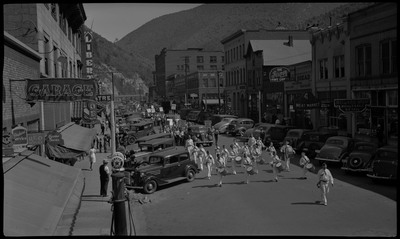 Children in a marching band during back-to-school parade. Spectators watch from the sidewalk.