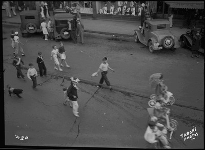 Children walking during the Benevolent and Protective Order of Elks roundup parade. A few spectators watch from the side of the street.