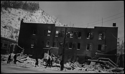 People walking in front of damage from the Ryan Hotel and Tabor Building fire. Snow covers some the damage.