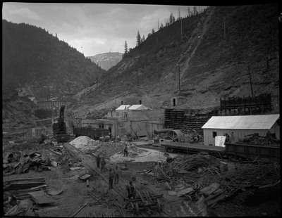 Several men are working and are surrounded by heaps of building materials after a fire in Burke, Idaho.