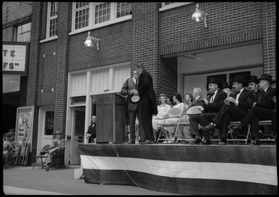 People standing and sitting on a stage during the Silver Jubilee.