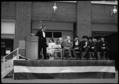 People standing and sitting on a stage during the Silver Jubilee.
