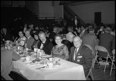 People dressed in formal wear seated at a table during the Silver Jubilee banquet.