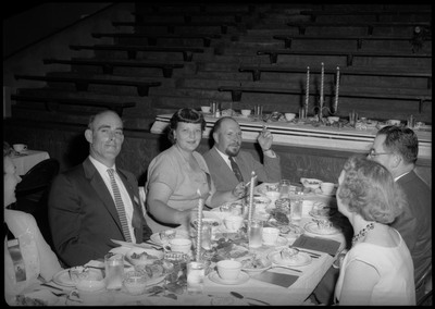People dressed in formal wear seated at a table during the Silver Jubilee banquet.