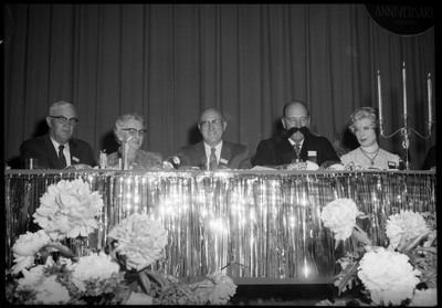 People dressed in formal wear seated at a table during the Silver Jubilee banquet.