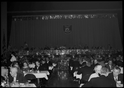 People dressed in formal wear seated at tables during the Silver Jubilee banquet.