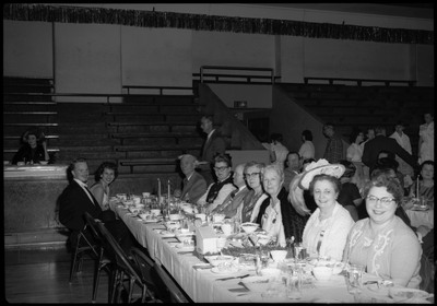 People dressed in formal wear seated at a table during the Silver Jubilee banquet.