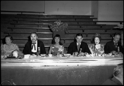 People dressed in formal wear seated at a table during the Silver Jubilee banquet.