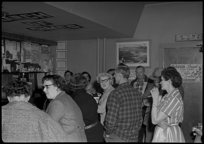 Scene during the Albie's March of Dimes event. People are sitting at the bar counter or standing.