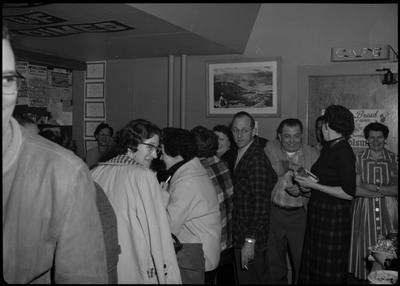 Image of the bar area and people standing behind the bar area during the Albie's March of Dimes event. There is decorative text on the ceiling.