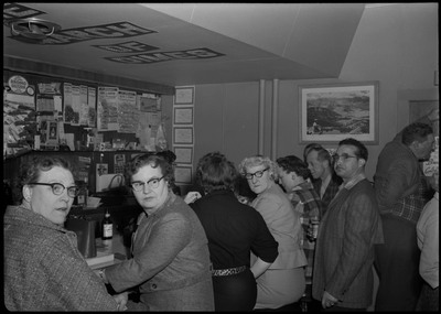 Scene during the Albie's March of Dimes event. People are sitting at the bar counter or standing.