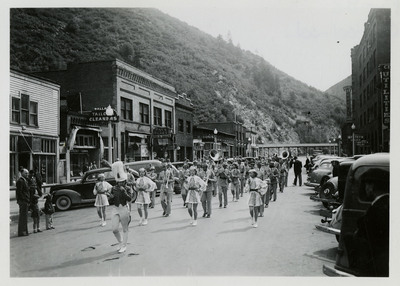 A drum major and majorettes lead a marching band along the parade route for the Benevolent and Protective Order of Elks parade.