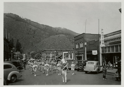 A drum major and majorettes lead a marching band along the parade route for the Benevolent and Protective Order of Elks parade.