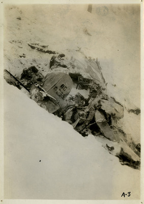 Debris from an airliner crash partially covered in snow.