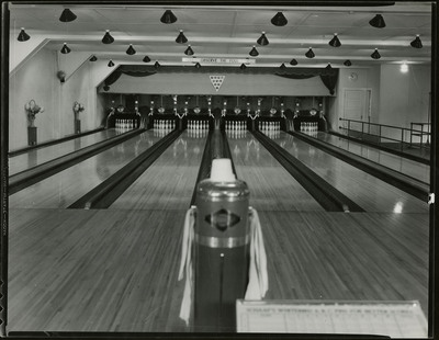 The interior of the Wallace bowling alley. A sign above the bowling lane reads "Please observe the foul line."