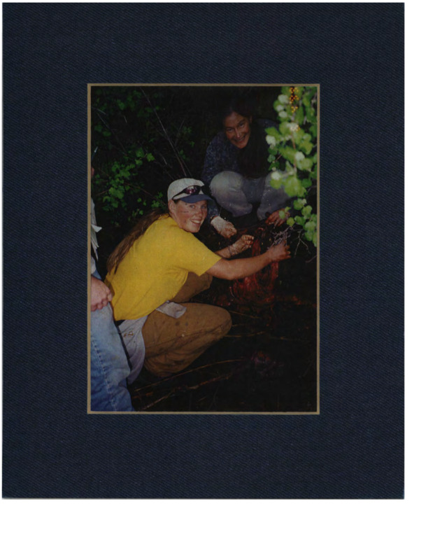 This image contains 3 individuals in the woods at night with a dead animals. Plants can be seen in the foreground and background. Categorized as "Students in the Field."