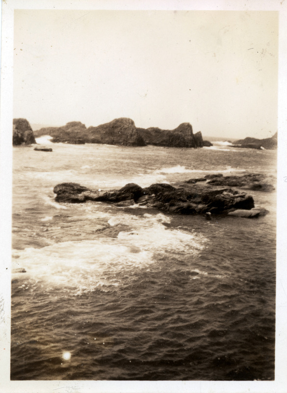 A close up of water moving around rocks. The back of the photograph is stamped with the number 234.