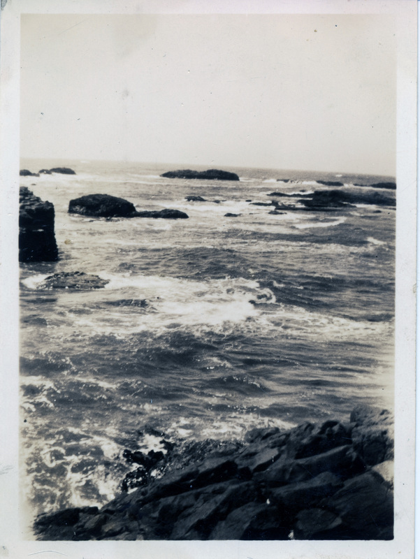 A close up of water moving around rocks. The back of the photograph is stamped with the number 234.