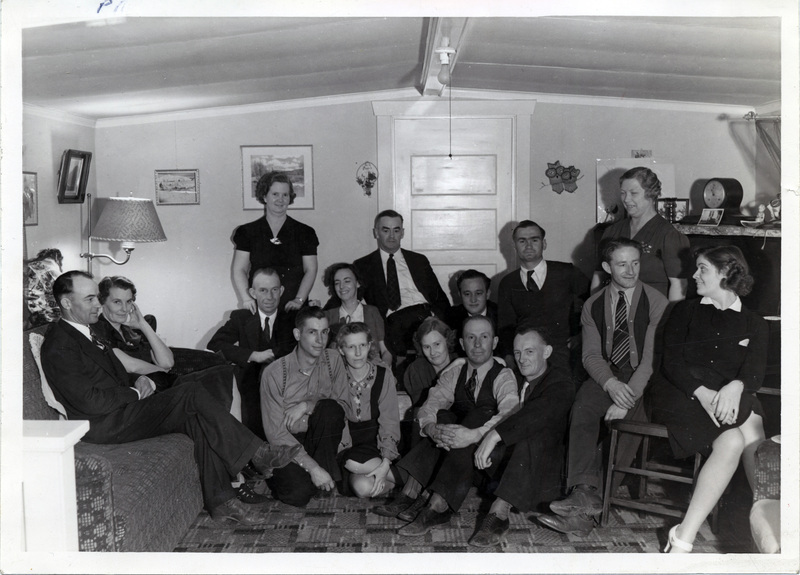 A large group of people pose for a photo in a room.