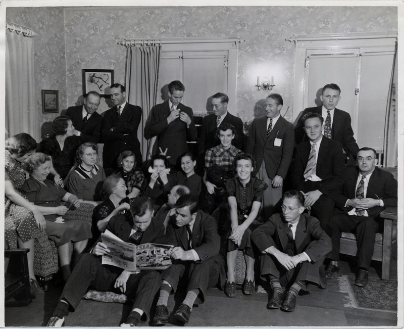 A large group of people pose for a photo in a room.