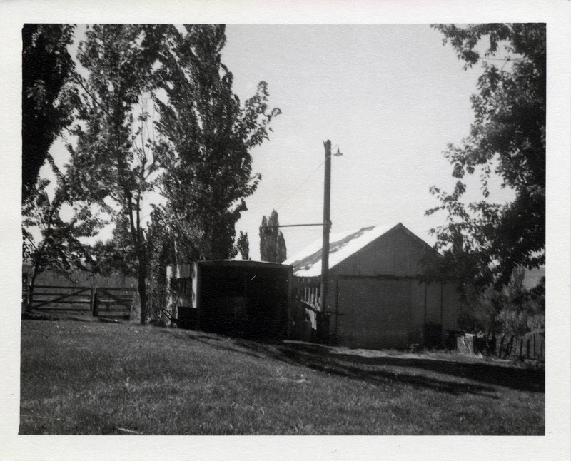 Two small buildings in a fenced yard.