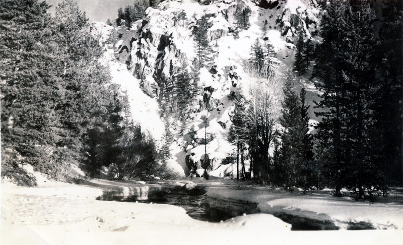 A stream flows through ice and snow next to a mountain. The back of the photograph is stamped with the number 29.