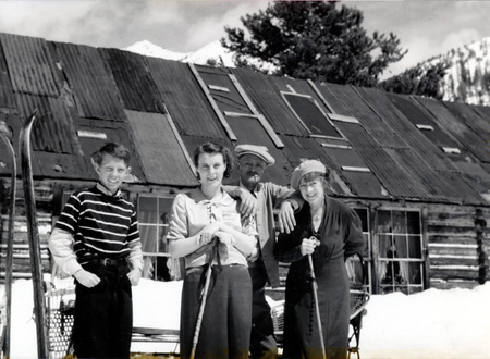 A close up photo of a man and a woman standing next to each other in front of a single-story house. "Rutherfords at Mascot Mine" is written on the back of the photograph.