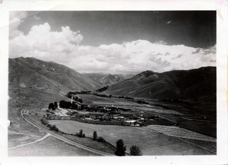 A view from above of the resort at the base of mountains."Sun Valley from Penny Mt., Thayer." is written on the back. The back of the photo is stamped with "Jul 21 1941."