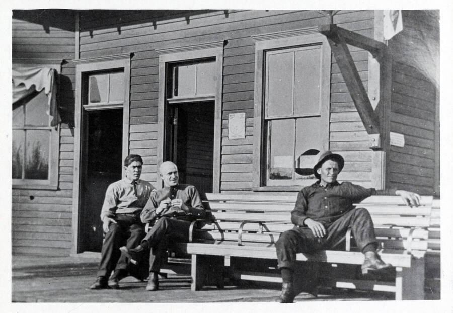Three men seated outside of the Washington, Idaho, & Montana railway depot in Bovill, Idaho. From left: Dick McDonald, John Scott, and Harry Roach