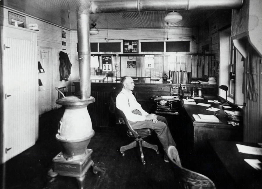 Chet Yangel sits at a desk in the Potlatch Lumber Company office in Bovill, Idaho.