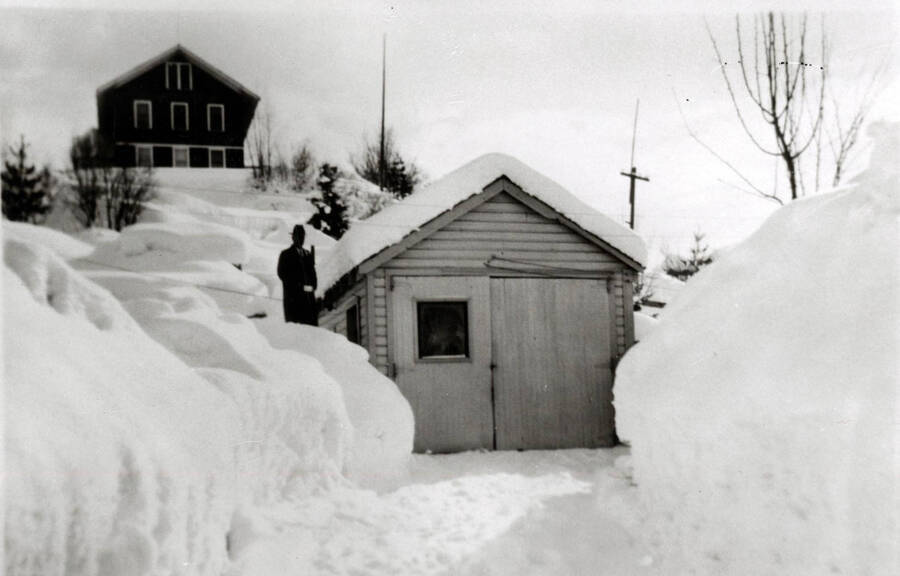 R.G. Morris standing near his garage in Elk River. Elk River Hospital in background.