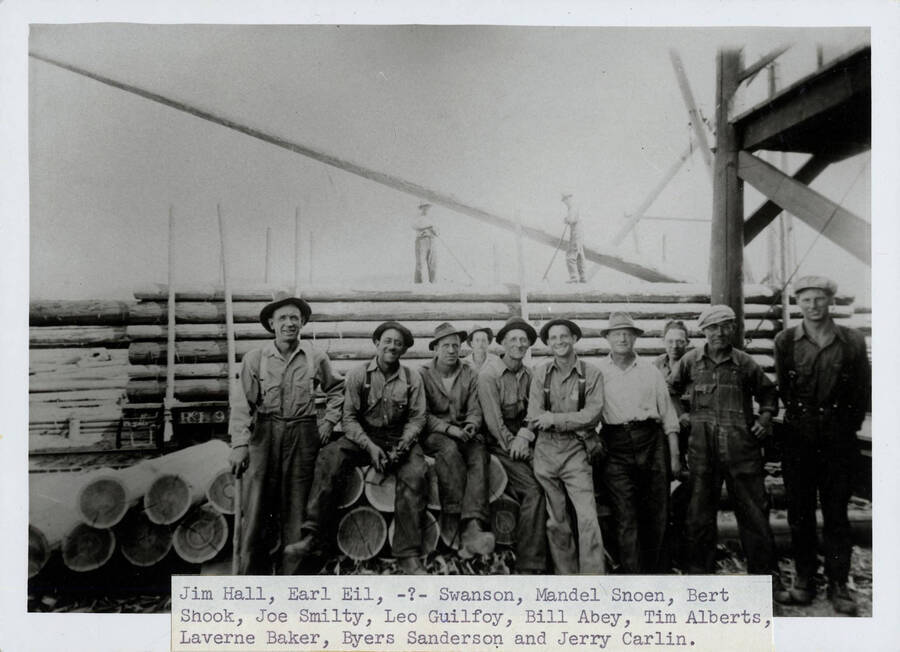 Left to right: Jim Hall, Earl Gil, Mr. Swanson, Mandel Snoen, Bert Shook, Joe Smiley, Leo Guilfoy, Bill Abey, Tim Alberts, Laverne Baker. Byers Sanderson and Jerry Carlin. are standing on the load.