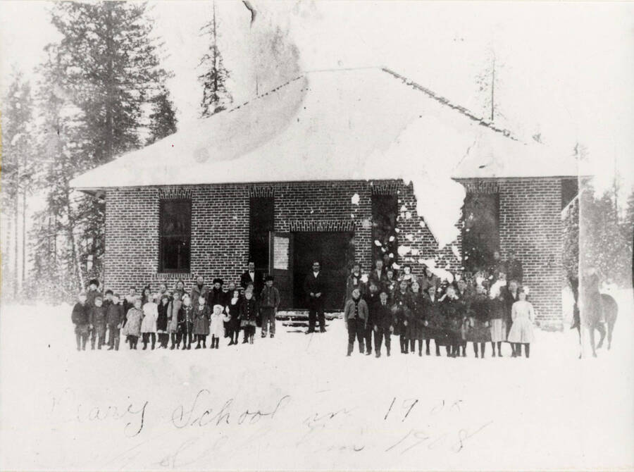 School children stand in front of the Deary school during winter.