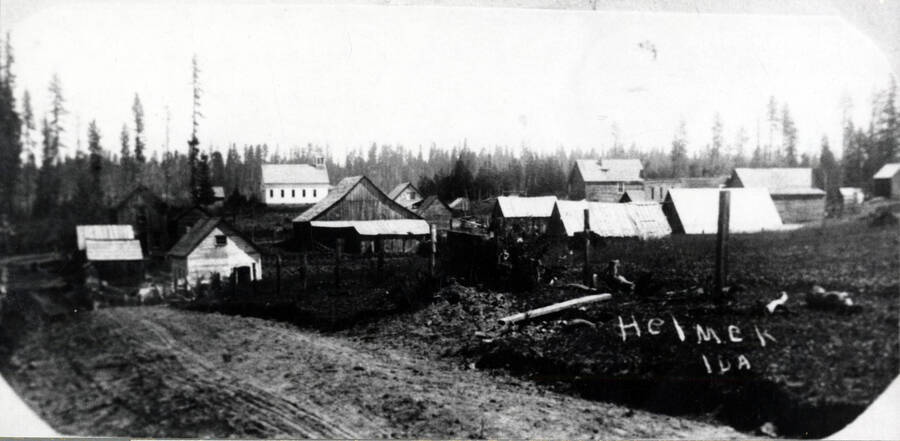 After construction of the new schoolhouse in 1908. The school, which stood at the north edge of town, is seen above the roof of the Wilkins barn. At right center is the Compo home. The buildings along Main Street are toward the right, half-hidden behind the nearby roofs.