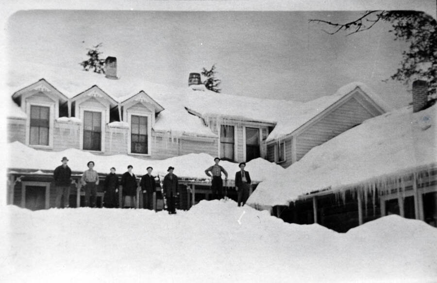 A big snowfall, seen at the Bovill Hotel. This, of April 1, 1917, is part of the heavy snow that fell in the corresponding winter. The photo also shows construction which forms the angle of the building and joins the former store (with added veranda, right) with the original hotel building (left). This central section was built in 1910 or thereabout. The 'post-office lean-to,' a structure added in 1908 on the south side of the store, does not show.