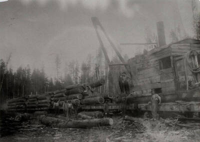 A work crew uses a jammer log loader