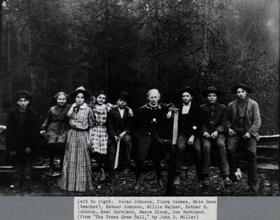 A teach and students from Bear Creek School, located between Deary and Avon, pose next to a fence. Left to right: Oscar Johnson, Clara Carmen, Miss Bean (teacher), Esther Johnson, Willie Walker, Esther E. Johnson, Axel Burkland, Rance Olson, Joe Burkland.