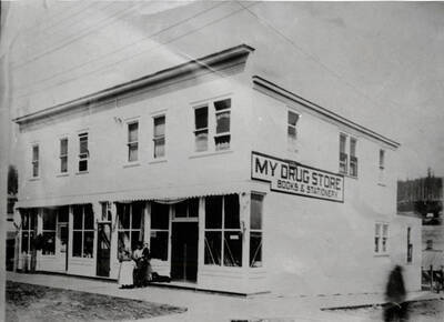 Morris drug store in Bovill, Idaho. Dr. R.T. Witty's dental office was in the upstairs corner. C.G. Morris and Eliza Morris are standing in front of the store.