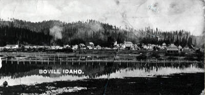 Seen at left center is the Opera House. Next to it is the David Boarding House, built after the 1912 fire, and at far left saloon building that burned in 1914. In the distance (center) is the Catholic Church and to its right, the school. The dark building in the semi-foreground is the Chapin home. In the original photo could be seen the studding of the dance hall wing which Chapin built to entertain prospective buyers of cedar poles. Toward the right is the square frame house which started as a brothel.