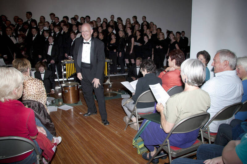 Photograph  18 of Dan Bukvich with Navin Chettri and the Jazz Choir I's Musical Performance 'The Village Sings and Drums and Dances, an evening of engaged voices and rhythms.' Dan Bukvich is Professor of Music. Navin Chettri is Bukvich's student. Pictured: Dan Bukvich and Jazz Choir I, University of Idaho Prichard Gallery.