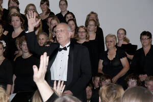 Photograph  3 of Dan Bukvich with Navin Chettri and the Jazz Choir I's Musical Performance 'The Village Sings and Drums and Dances, an evening of engaged voices and rhythms.' Dan Bukvich is Professor of Music. Navin Chettri is Bukvich's student. Pictured: Dan Bukvich and Jazz Choir I, University of Idaho Prichard Gallery.