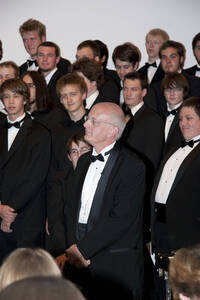 Photograph  4 of Dan Bukvich with Navin Chettri and the Jazz Choir I's Musical Performance 'The Village Sings and Drums and Dances, an evening of engaged voices and rhythms.' Dan Bukvich is Professor of Music. Navin Chettri is Bukvich's student. Pictured: Dan Bukvich and Jazz Choir I, University of Idaho Prichard Gallery.