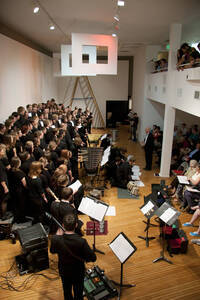 Photograph  7 of Dan Bukvich with Navin Chettri and the Jazz Choir I's Musical Performance 'The Village Sings and Drums and Dances, an evening of engaged voices and rhythms.' Dan Bukvich is Professor of Music. Navin Chettri is Bukvich's student. Pictured: Dan Bukvich and Jazz Choir I, University of Idaho Prichard Gallery.