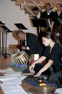 Photograph  13 of Dan Bukvich with Navin Chettri and the Jazz Choir I's Musical Performance 'The Village Sings and Drums and Dances, an evening of engaged voices and rhythms.' Dan Bukvich is Professor of Music. Navin Chettri is Bukvich's student. Pictured: Navin Chettri and performers from Jazz Choir I, University of Idaho Prichard Gallery.